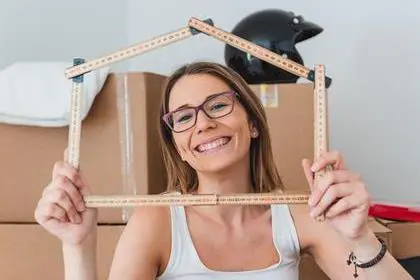 girl smiling and holding house frame during moving
