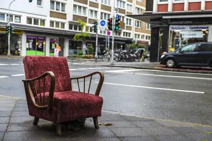 Old armchair vintage garnet lying on the street in Dusseldorf, Germany